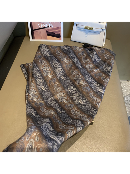 Brown, charcoal and cream paisley scarf spread in a flowing drape