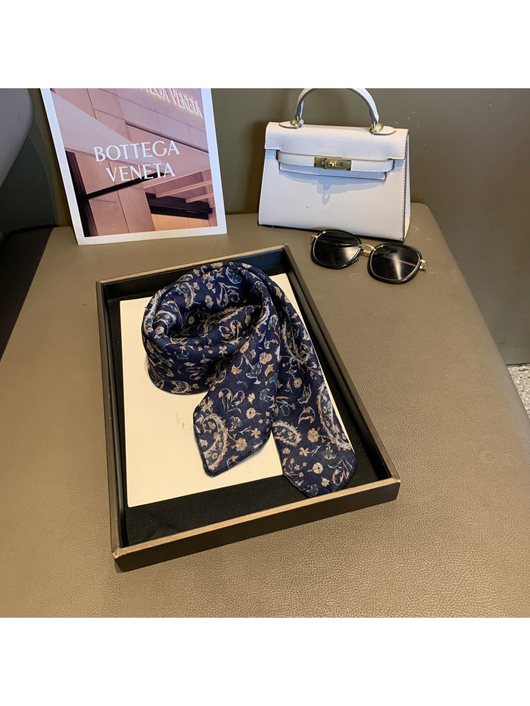 Navy paisley and floral scarf loosely draped on a display tray