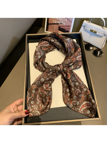 Coffee paisley and floral scarf tied in a loop on a display tray