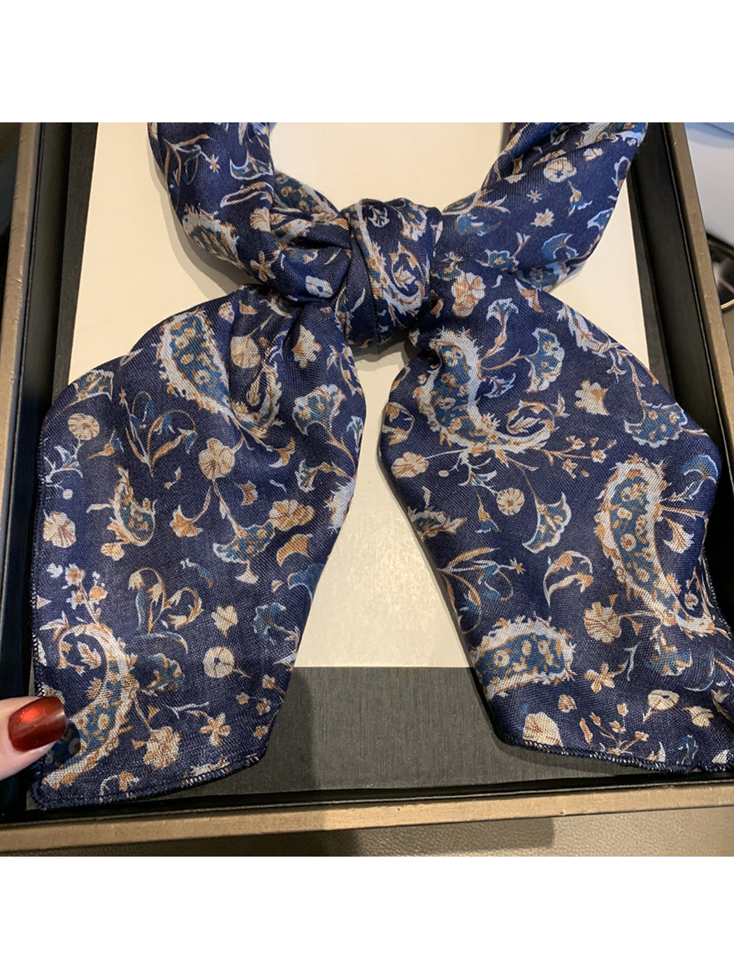 Close-up of the Navy scarf's paisley print and narrow stitched edge