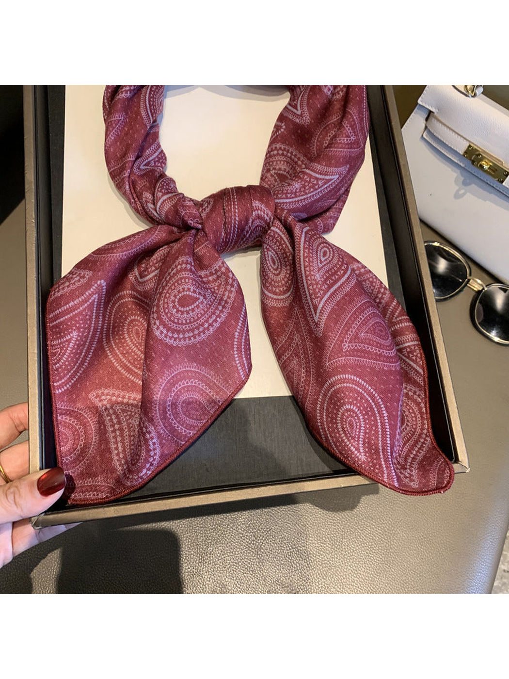 Close-up of the Burgundy scarf's paisley pattern and narrow stitched edge