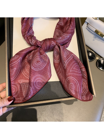 Close-up of the Burgundy scarf's paisley pattern and narrow stitched edge
