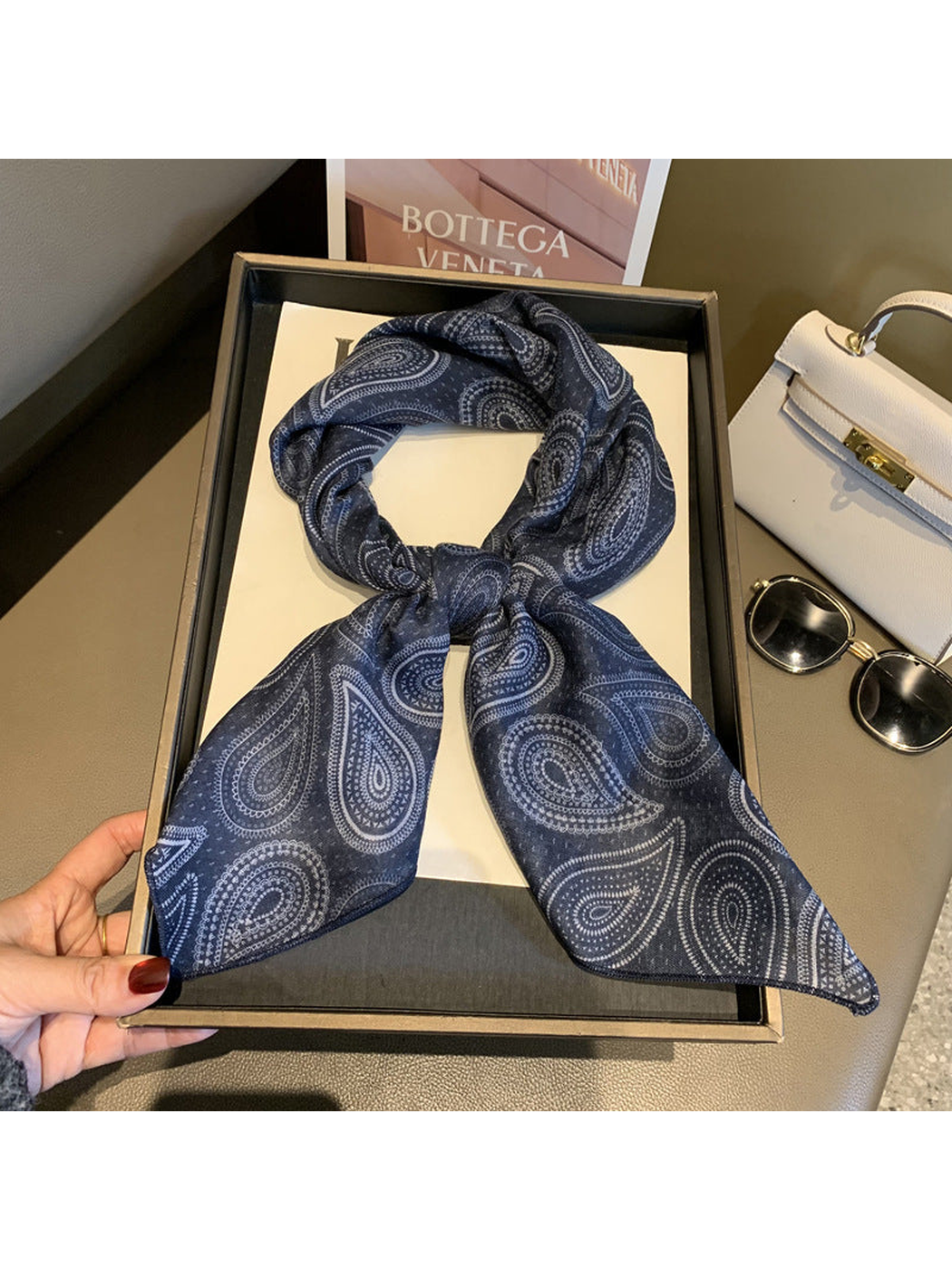 Navy paisley scarf tied in a loop with draped ends