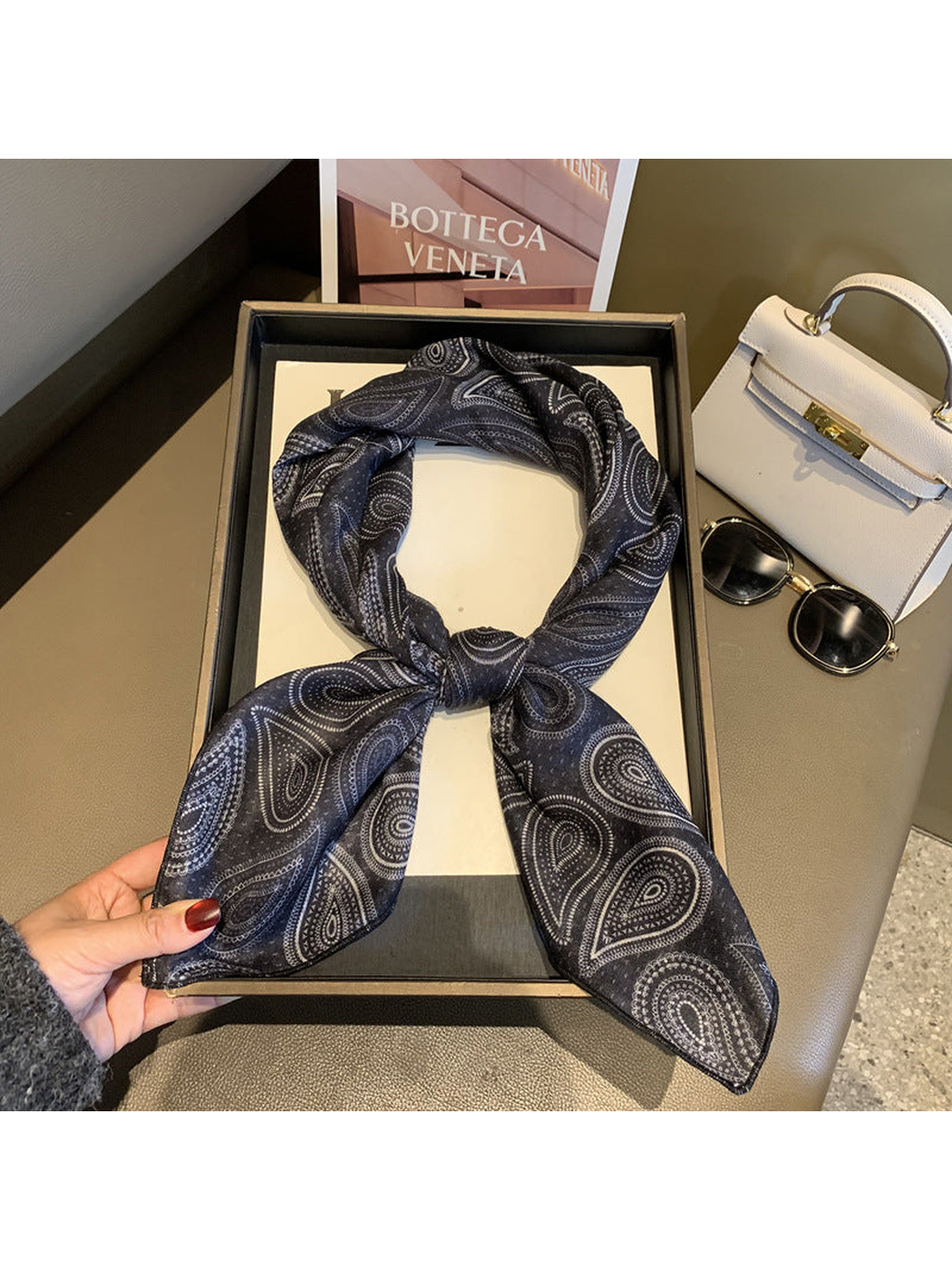 Black paisley scarf tied in a loop with draped ends