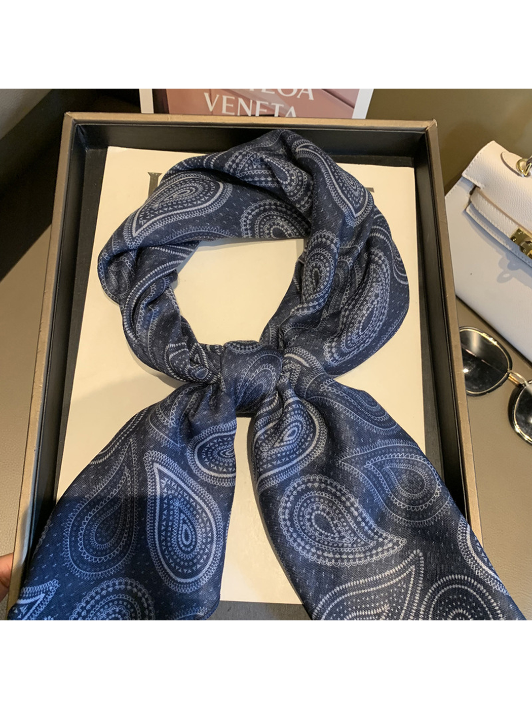 Close-up of the Navy scarf's paisley pattern and tied center