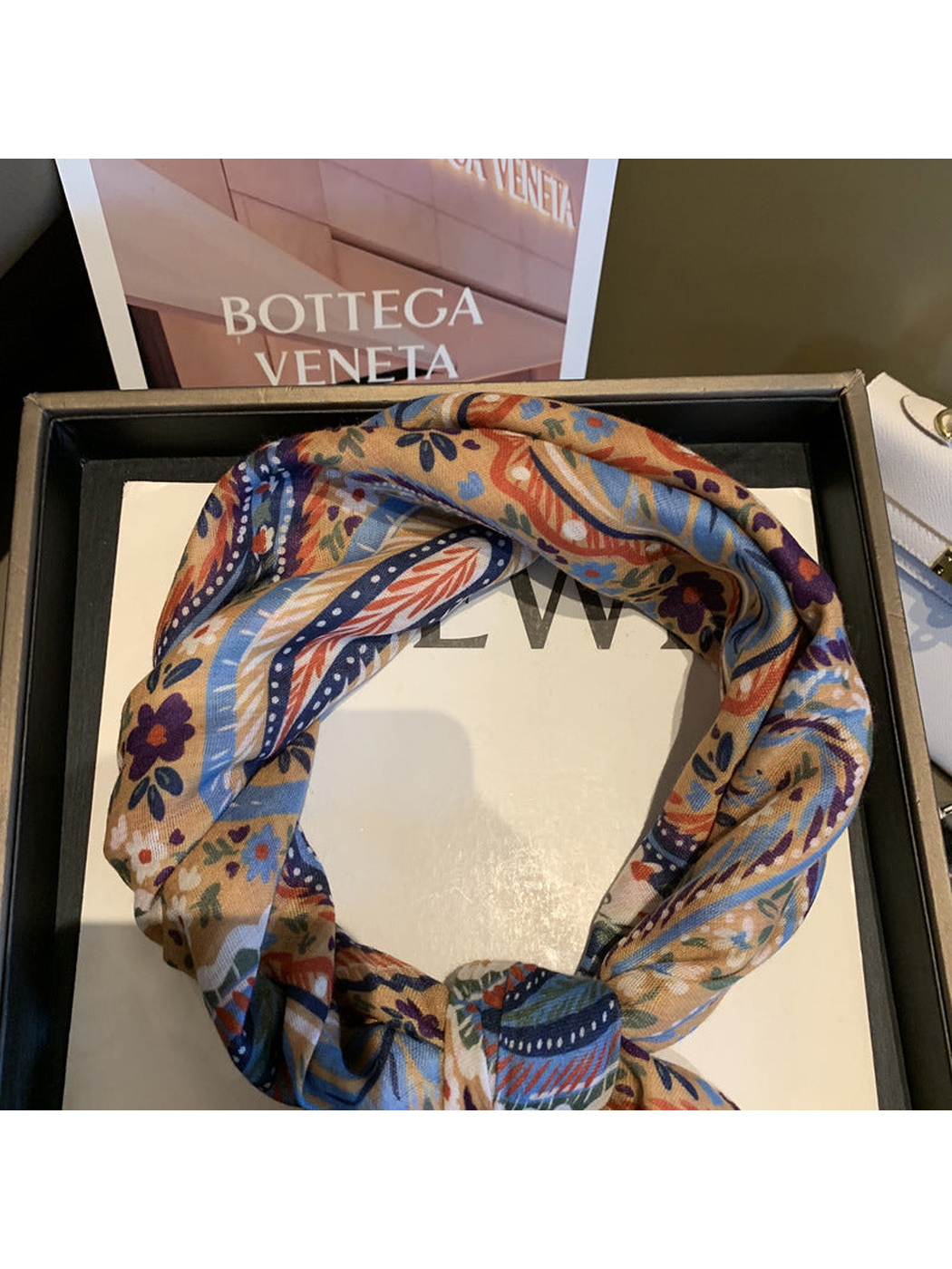 Close-up of the Beige scarf's paisley pattern and looped styling