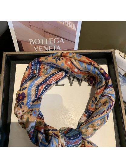Close-up of the Beige scarf's paisley pattern and looped styling