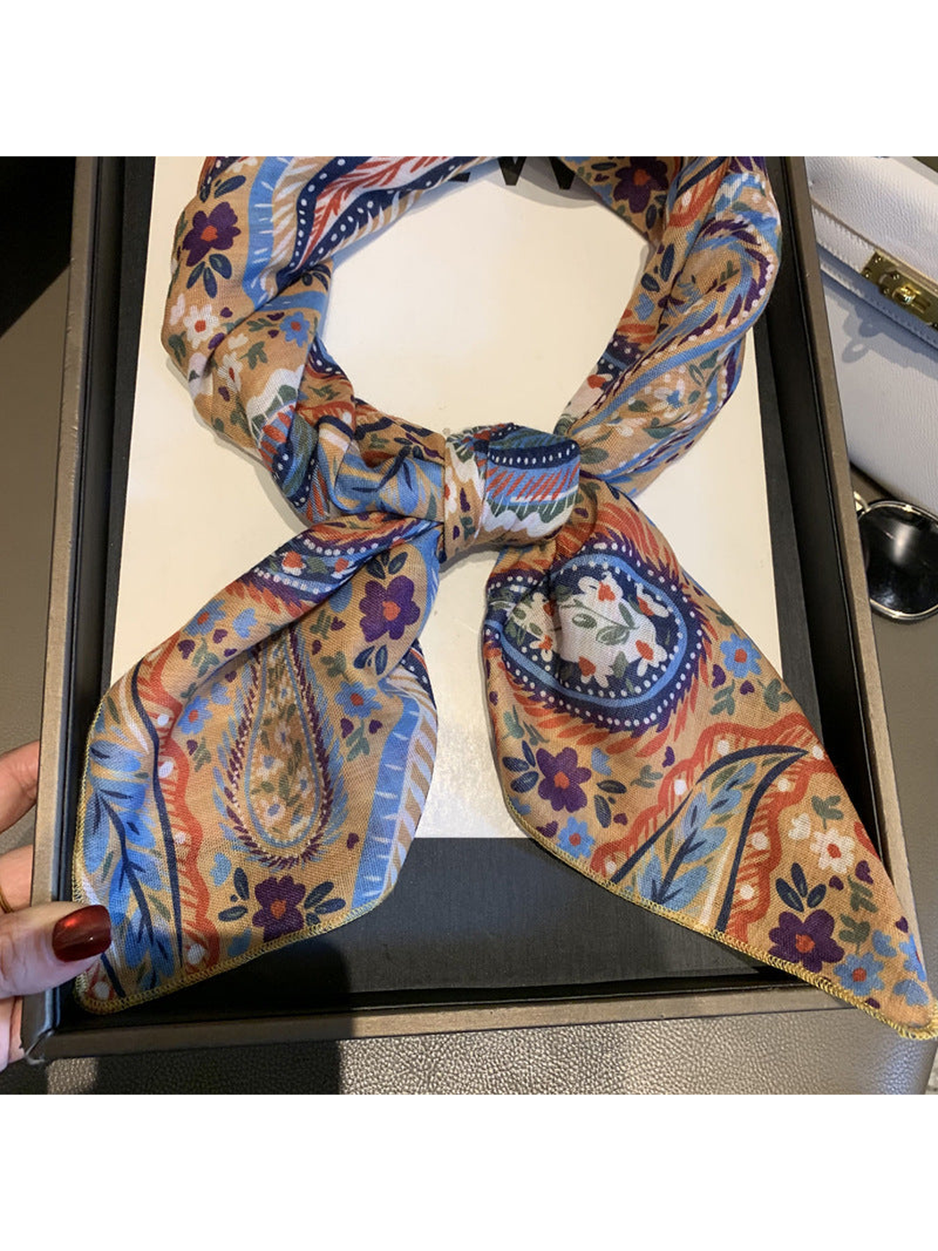 Close-up of the Beige scarf knot, patterned ends and stitched edging