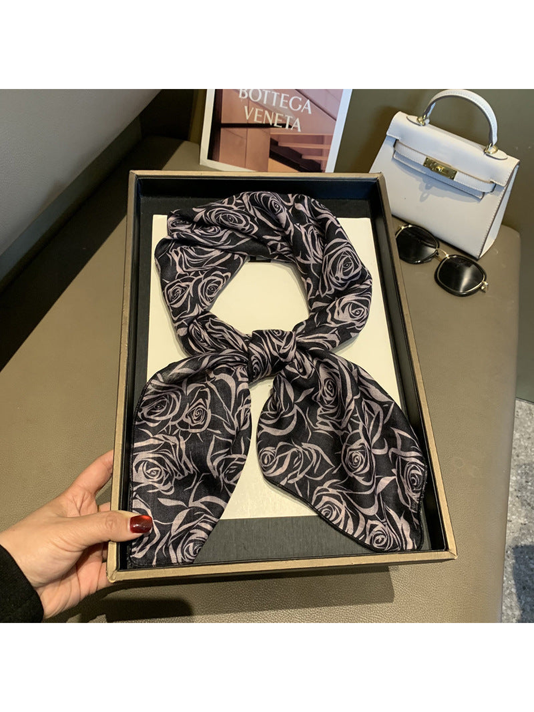 Black square scarf with pale pink rose pattern, tied view