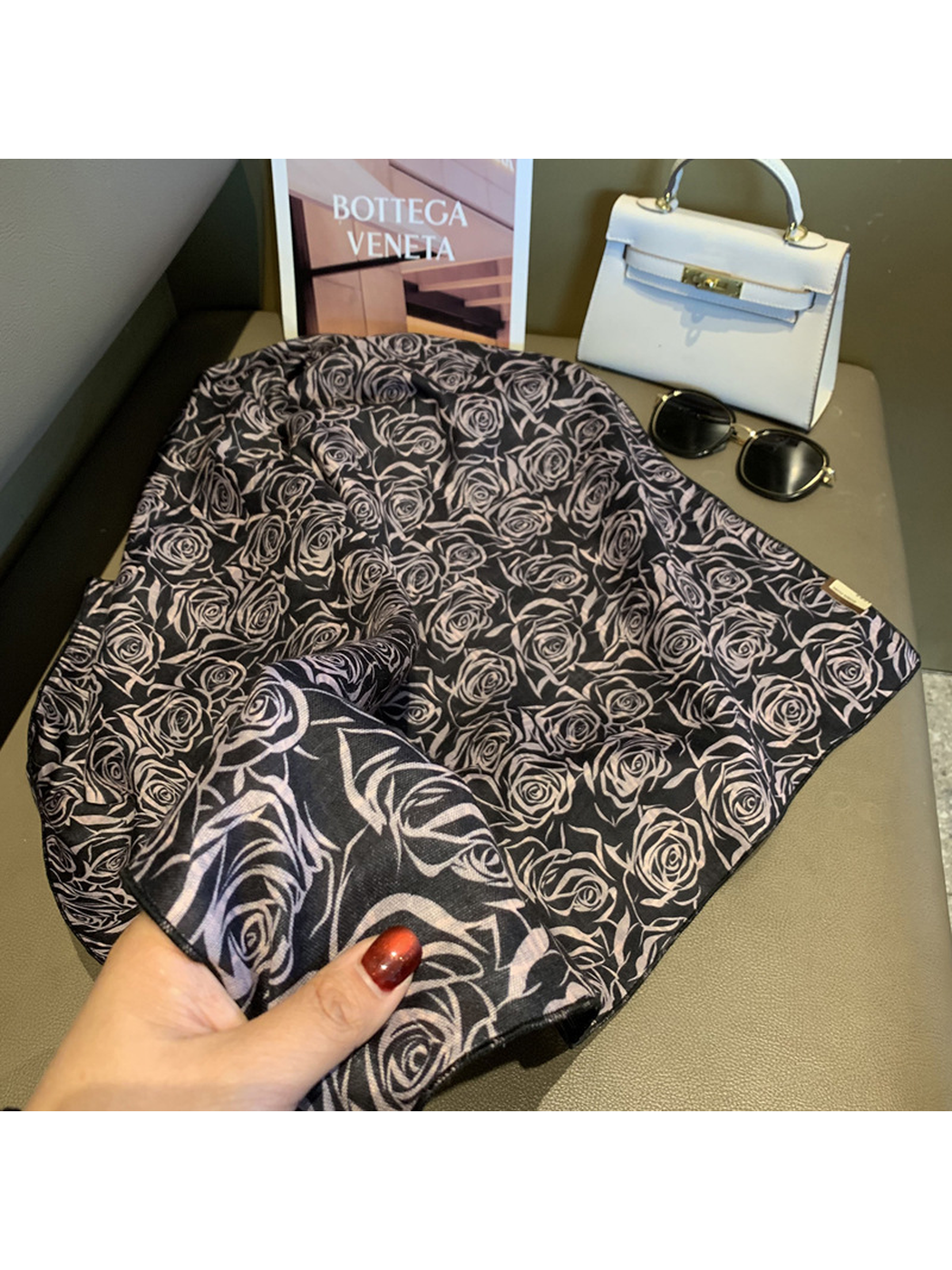 Close-up of the black scarf's rose pattern, reverse side and stitched edge