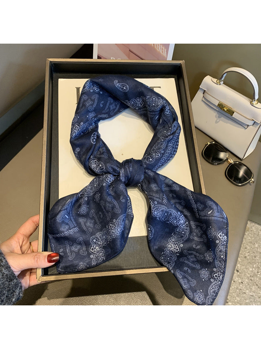 Navy paisley scarf tied in a looped knot
