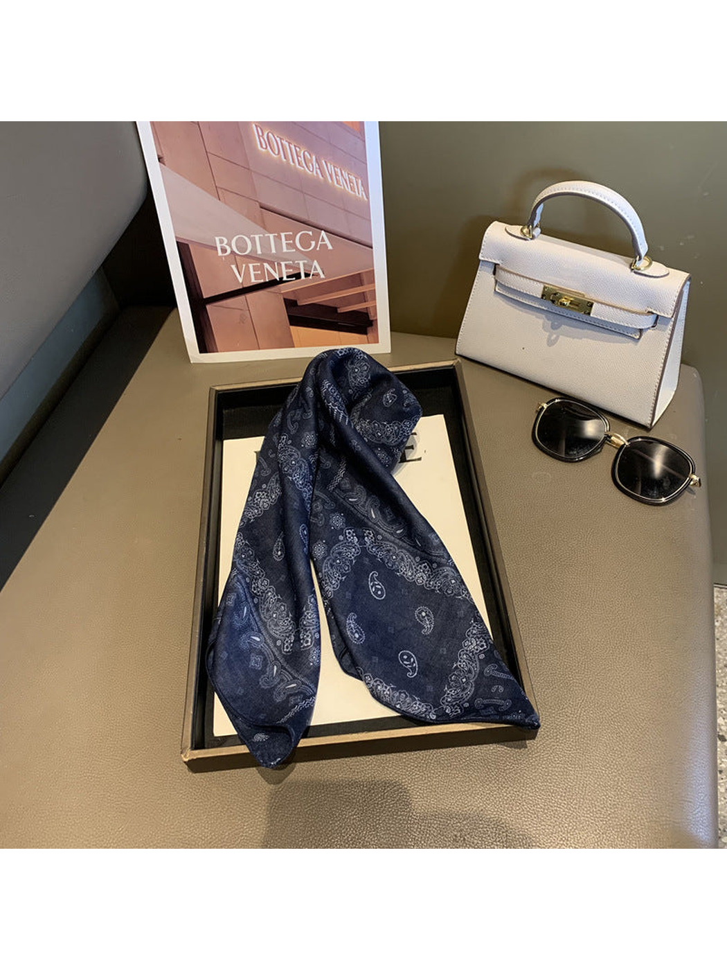 Navy paisley scarf arranged in a loose draped knot