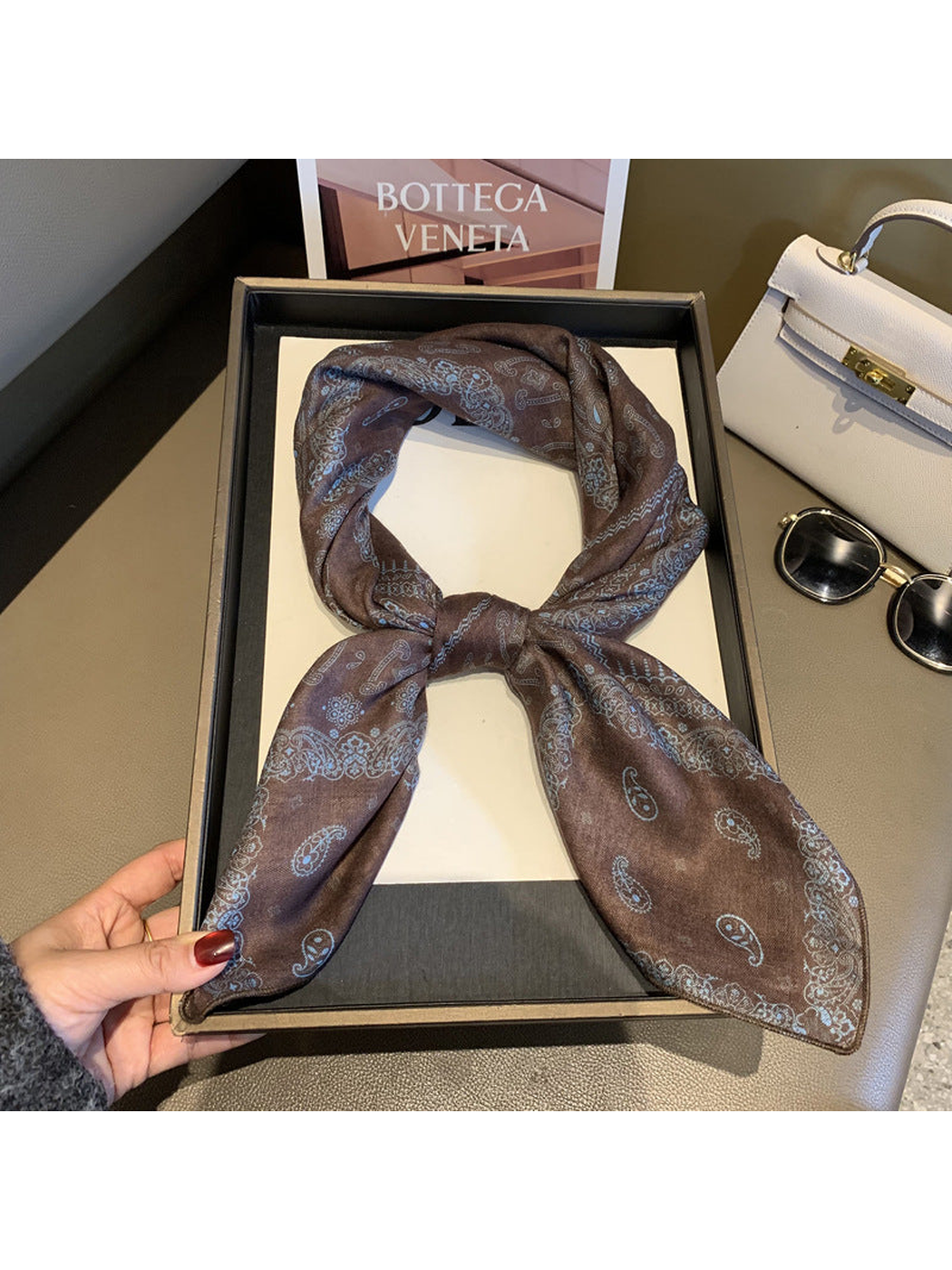 Brown paisley scarf tied in a looped knot