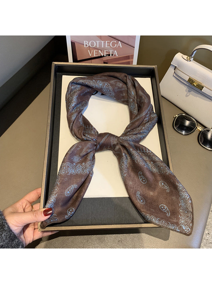 Brown paisley scarf tied in a looped knot