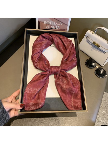 Burgundy paisley scarf tied in a looped knot