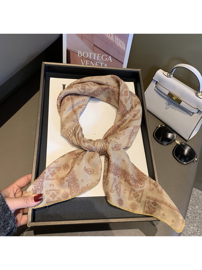 Beige paisley scarf tied in a looped knot