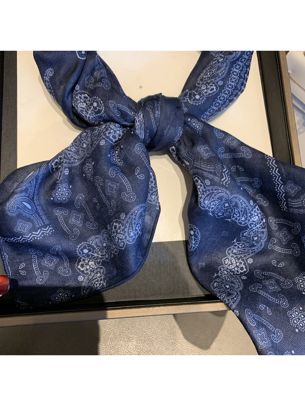 Close-up of the Navy scarf knot, paisley pattern and finished edge