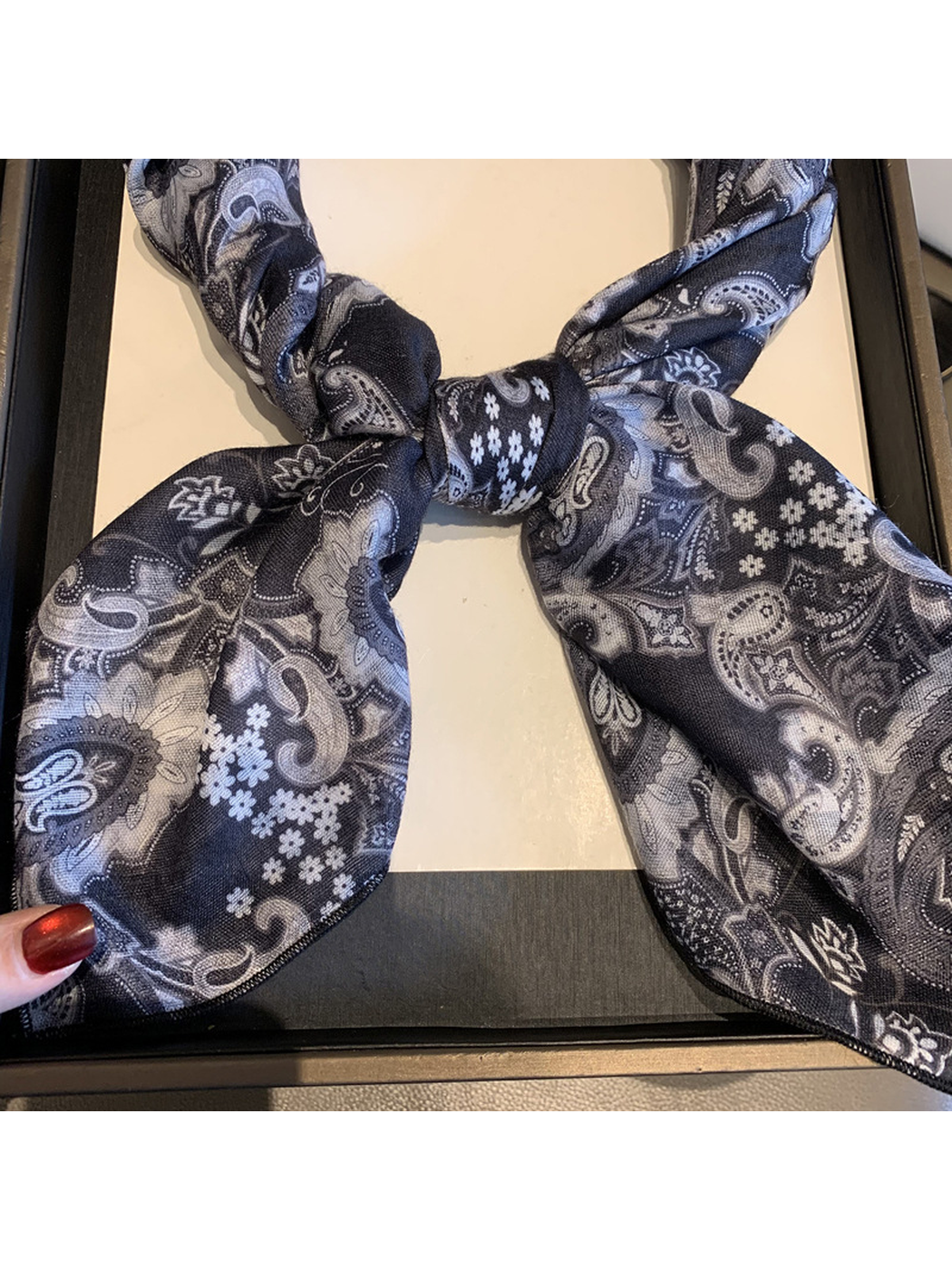 Close-up of the paisley scarf knot and narrow stitched edge
