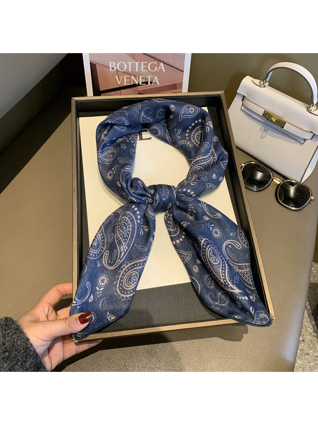 Navy paisley scarf tied in a loop in a styled tabletop setting