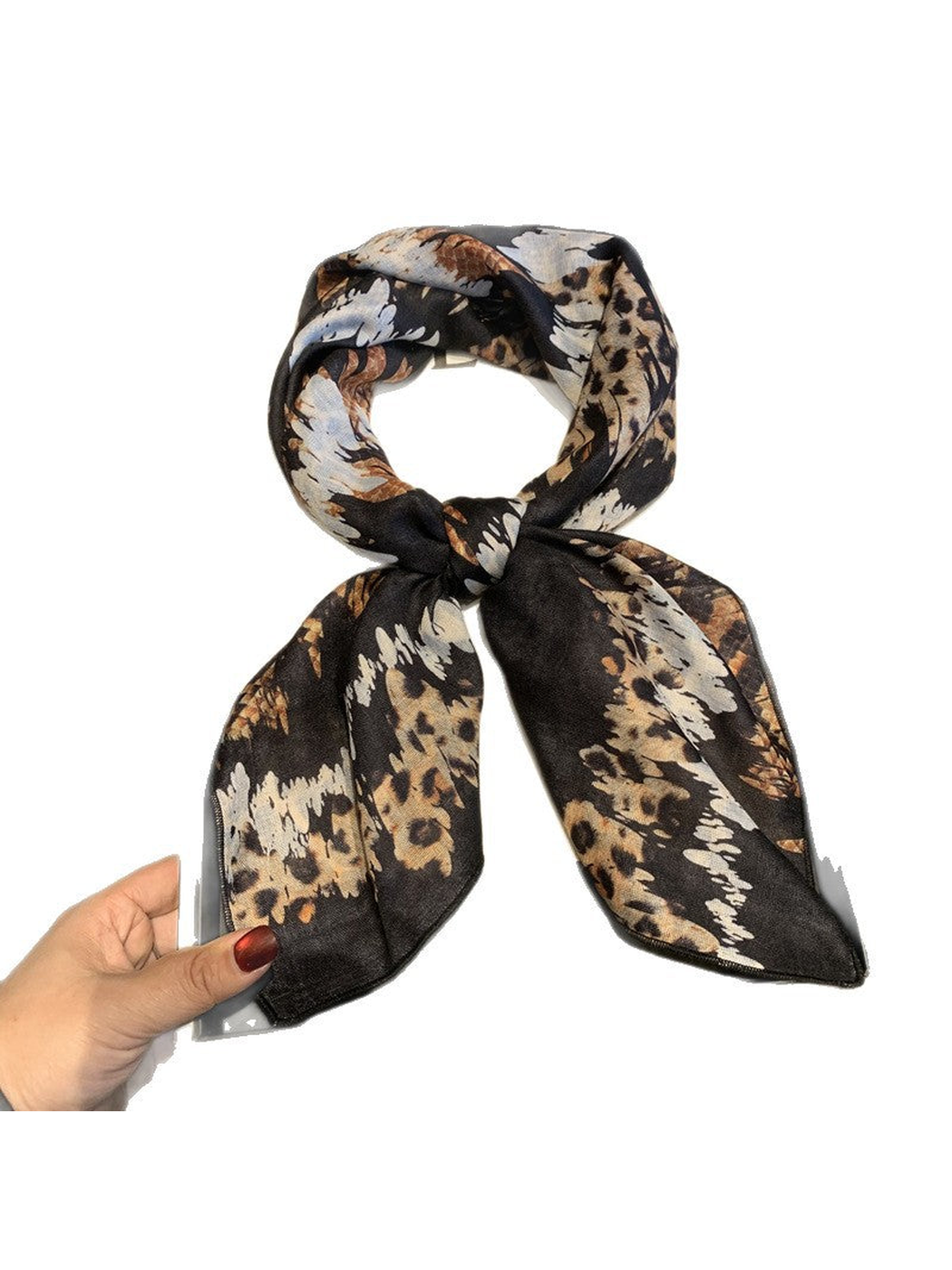 Black, tan and cream animal-print scarf tied against a white background