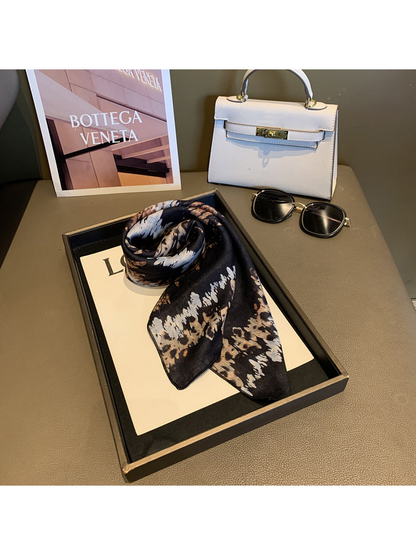 Black, tan and cream animal-print scarf arranged in a compact rolled tie
