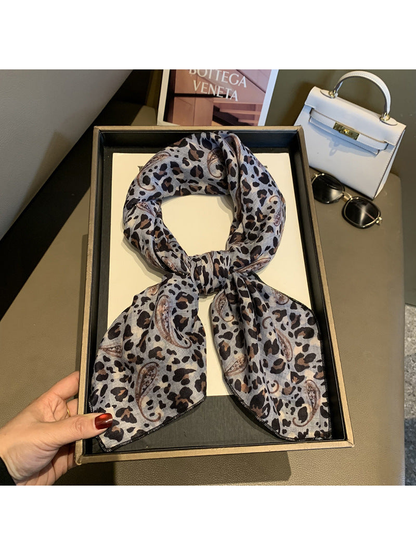 Gray leopard and paisley scarf tied in a loop on a display tray