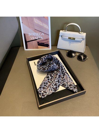 Gray leopard and paisley scarf loosely draped on a display tray