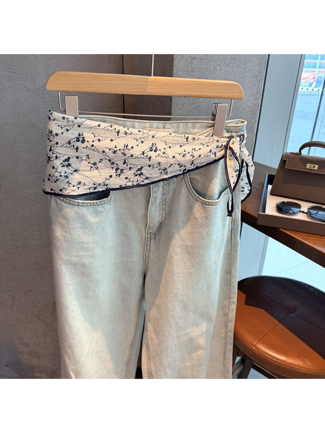 Navy floral triangle scarf tied as a sash around light-wash jeans