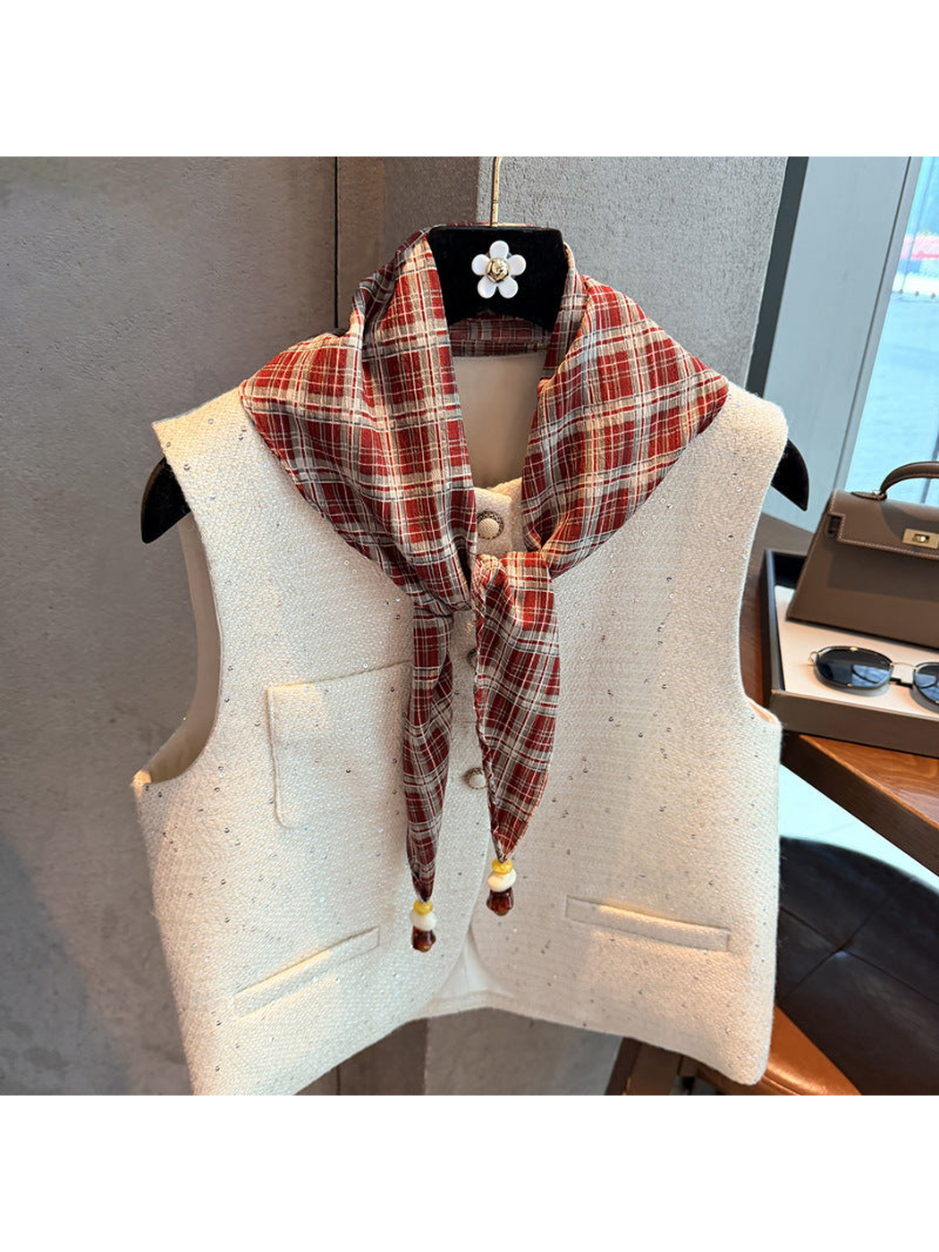 Red plaid scarf tied at the front over a white vest