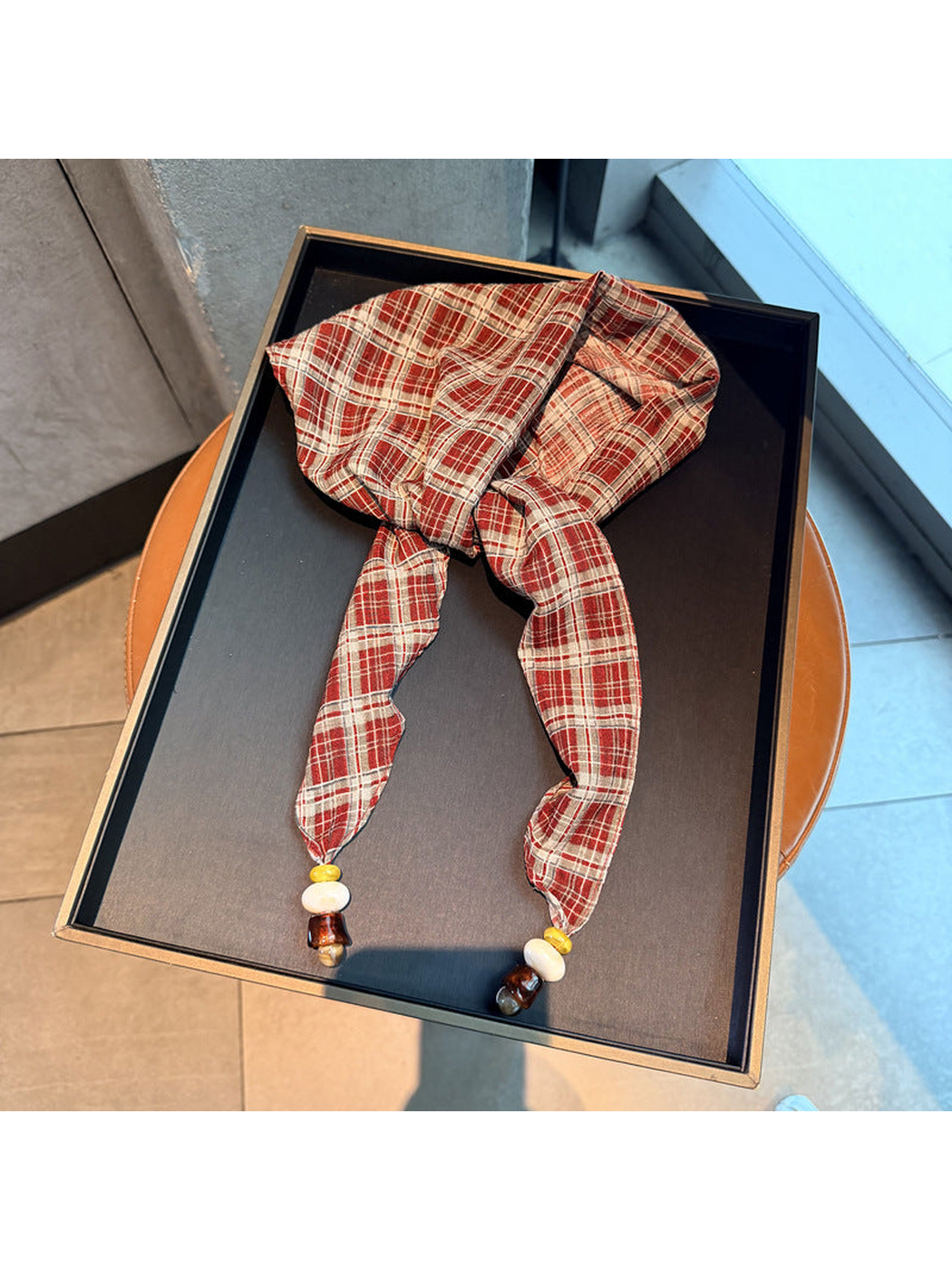 Red plaid scarf with tapered ends and bead accents, full view