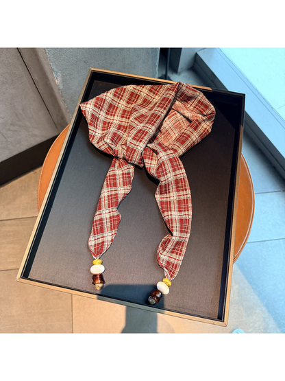 Red plaid scarf with tapered ends and bead accents, full view