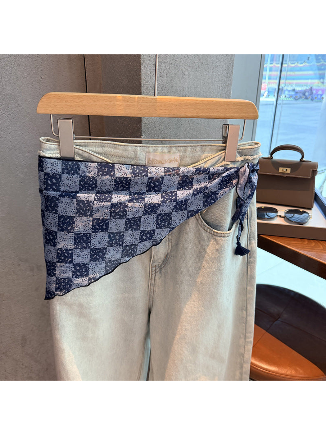 Navy checkerboard floral triangle scarf tied around light-wash jeans