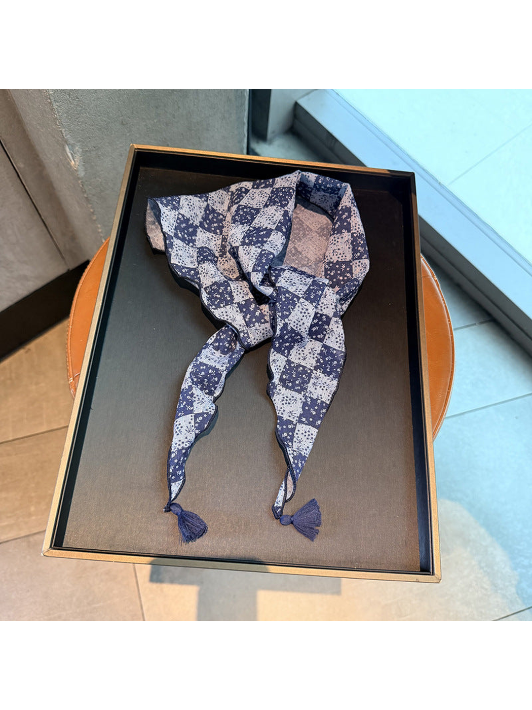 Navy checkerboard floral triangle scarf with tassel ends, tied display
