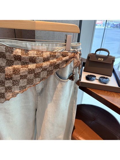 Close-up of the brown scarf tie, scalloped edge and tassel ends