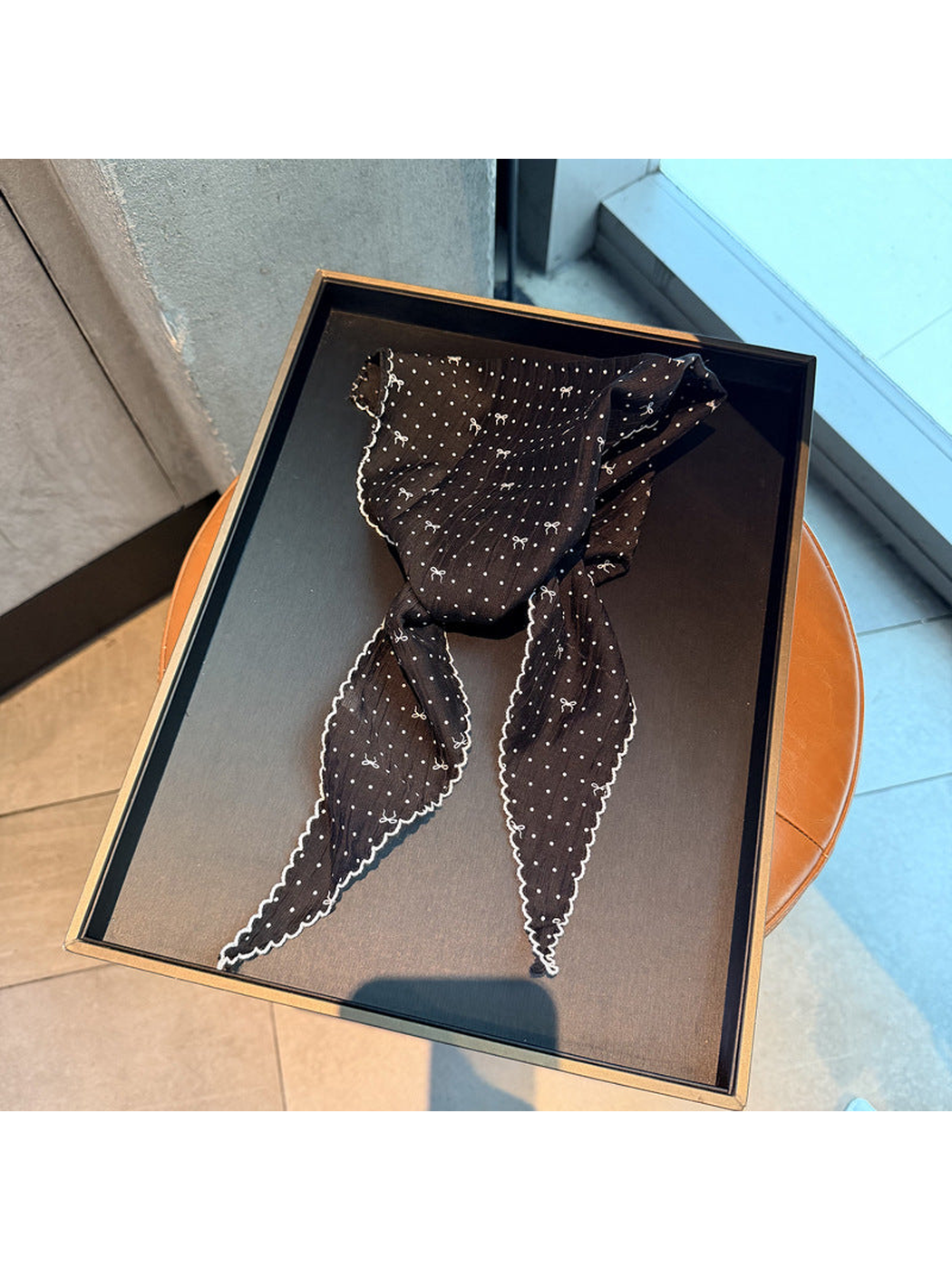 Black polka-dot triangle scarf with small bow motifs and scalloped edging