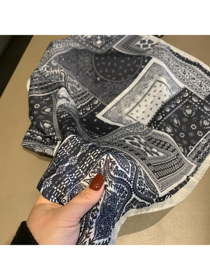 Close-up of the navy and ivory paisley pattern and fringed edge