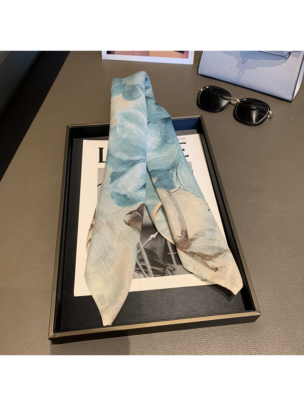 Blue-gray floral scarf loosely draped with tapered ends