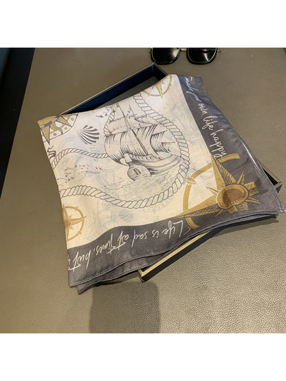 Folded cream and gray square scarf with sailing ship and compass print