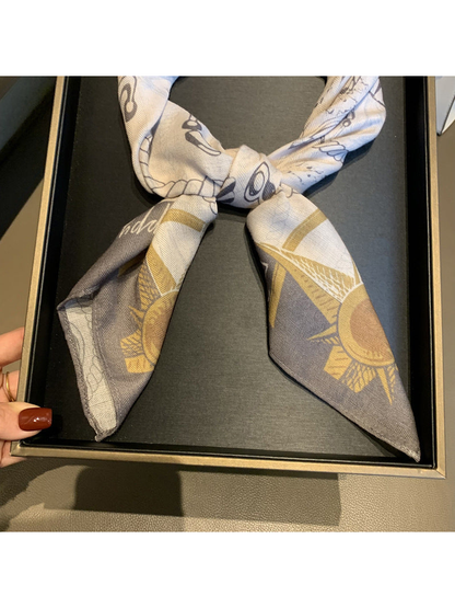 Close-up of the knotted scarf with gray and muted gold pointed ends