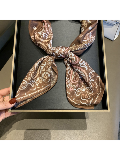 Close-up of the knot and pointed paisley ends on the brown scarf