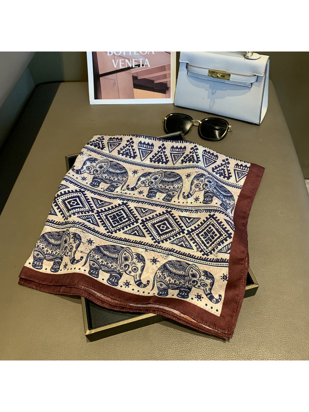 Square scarf laid open to show elephant and geometric pattern bands