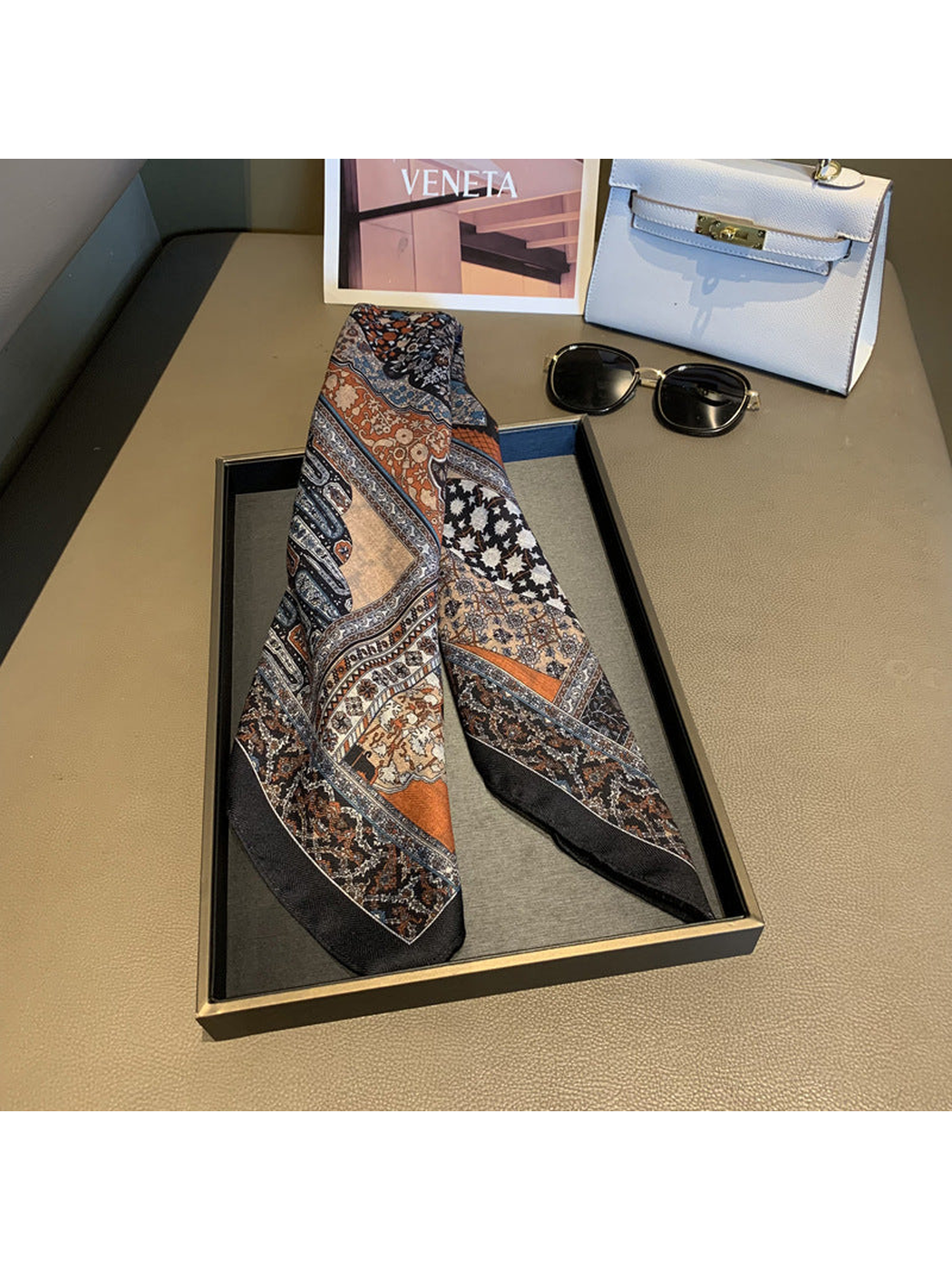Multicolor patchwork-print scarf folded into a narrow draped shape