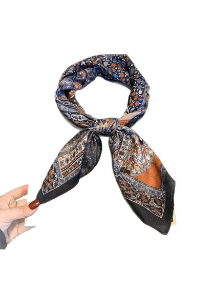 Multicolor patchwork-print square scarf tied in a looped knot on white