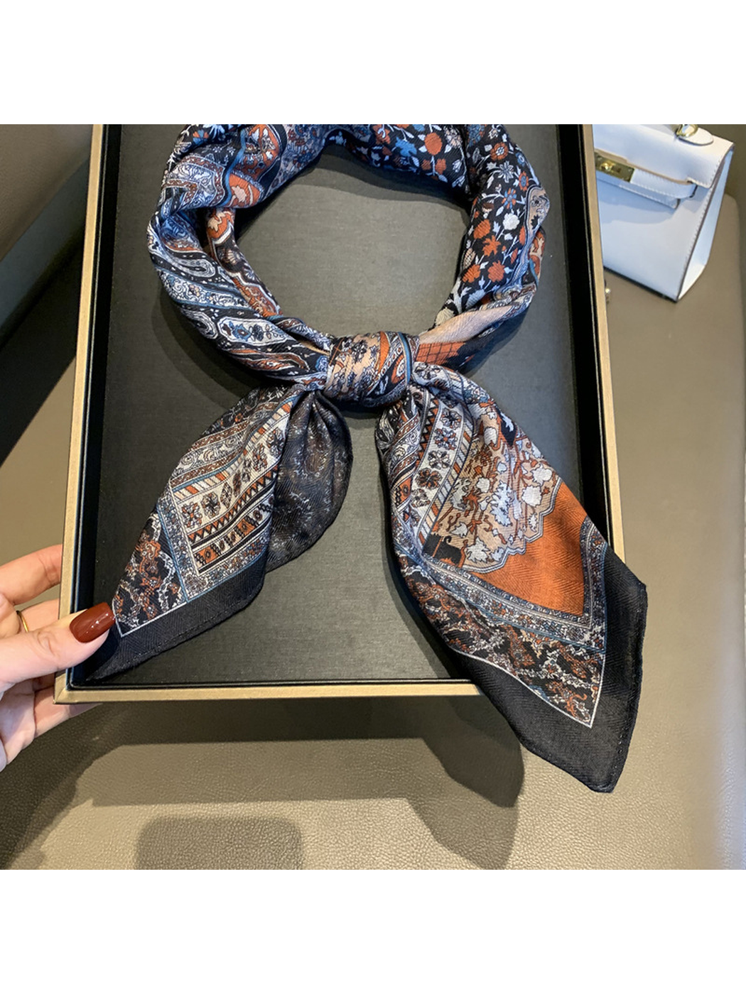 Close-up of the scarf's looped knot, patterned ends and dark border