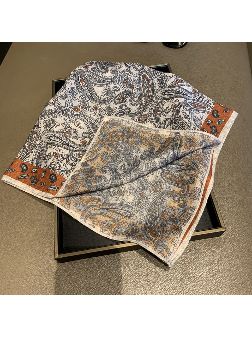 Paisley square scarf folded back to reveal its lighter reverse side