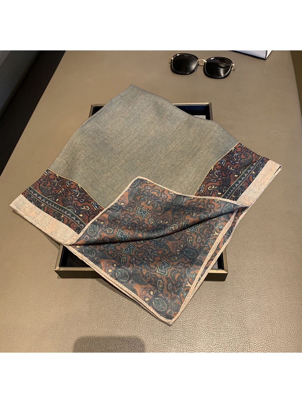 Folded scarf detail showing both patterned faces and the stitched edge