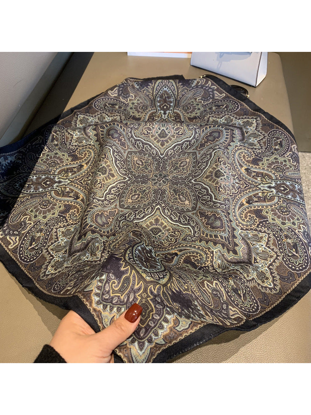 Close-up of the scarf's symmetrical paisley medallion and dark border