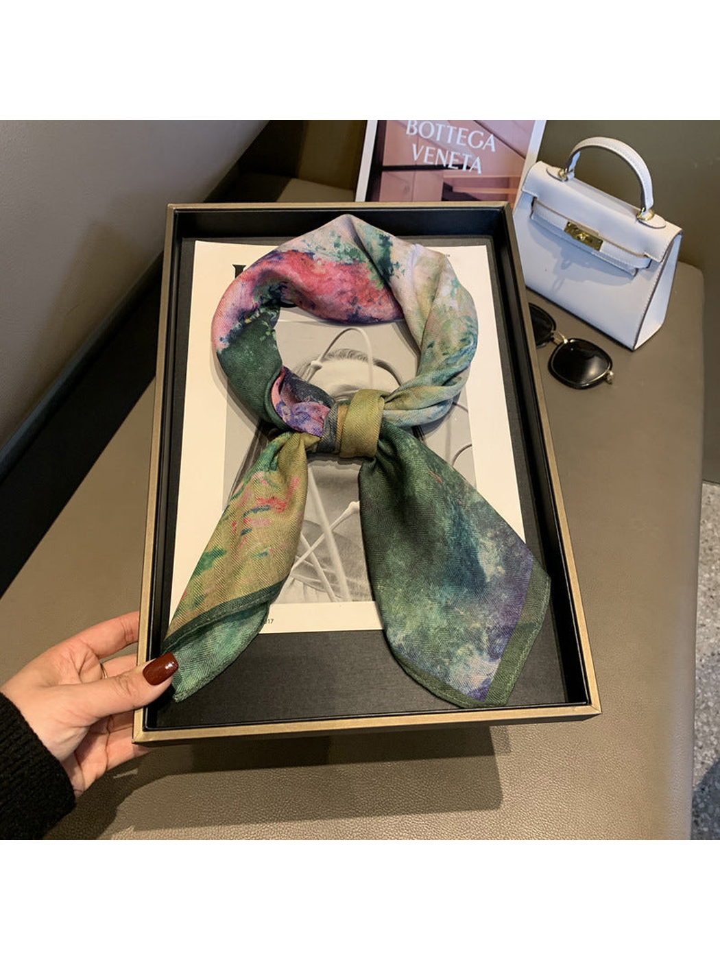 Multicolor square scarf arranged in a loose knot with tapered ends