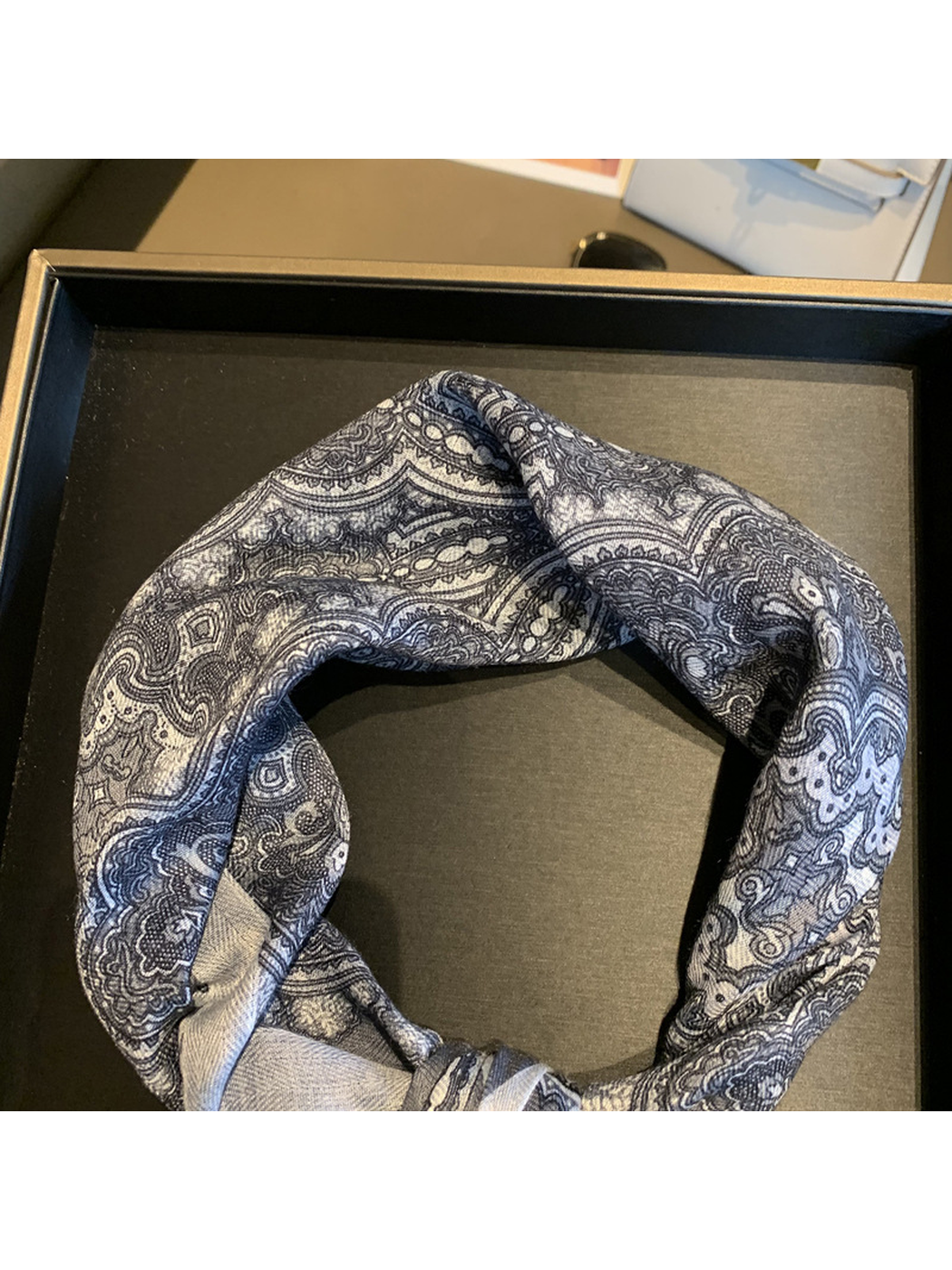 Close-up of the gray-blue paisley scarf pattern and fine woven-look texture