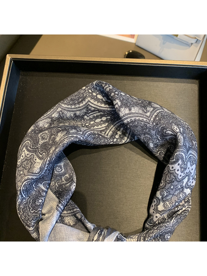 Close-up of the gray-blue paisley scarf pattern and fine woven-look texture